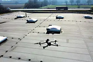 Drohen fliegt über ein Industriedach.