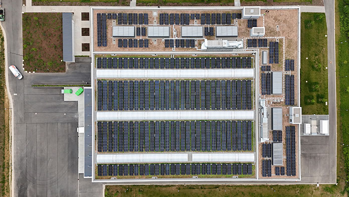 Draufsicht auf das Dach des MBPS-Neubaus mit Photovoltaikmodulen, begrünten Flächen und Oberlichtern.
